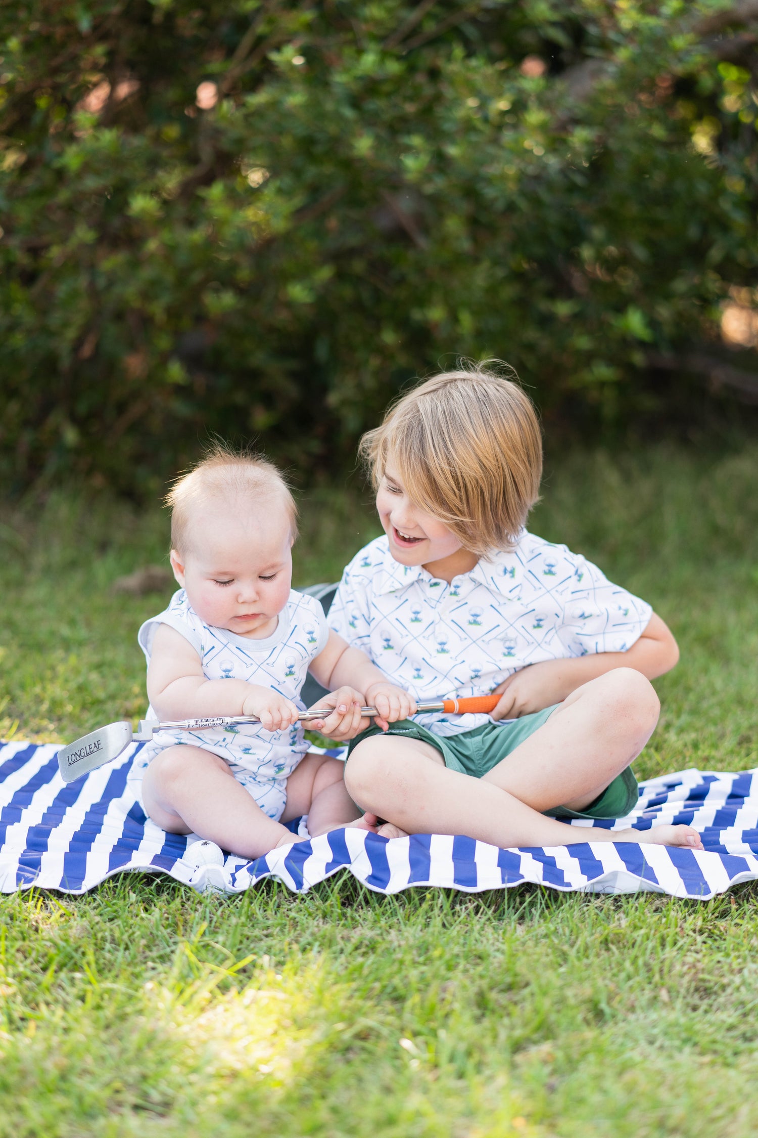 brother matching outfits. two boys sitting on a blanket in matching outfits.